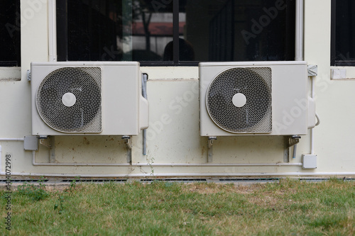 Air compressor or air condenser unit located on support outside building to heat released transferred to surrounding environment, Compressor is part of cooling function and air conditioning