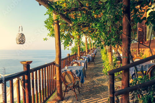 Fototapeta Naklejka Na Ścianę i Meble -  A beautiful restaurant with lemon trees overlooking the coast in Italy.