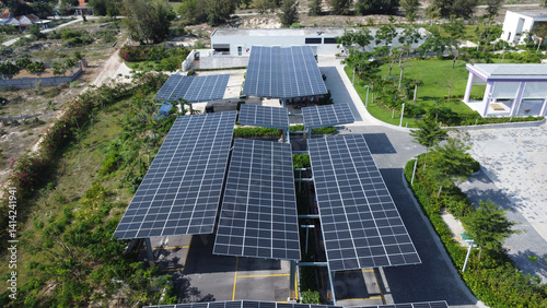 Aerial view of solar power plant with blue photovoltaic panels mounted on parking garage. Production of sustainable energy concept