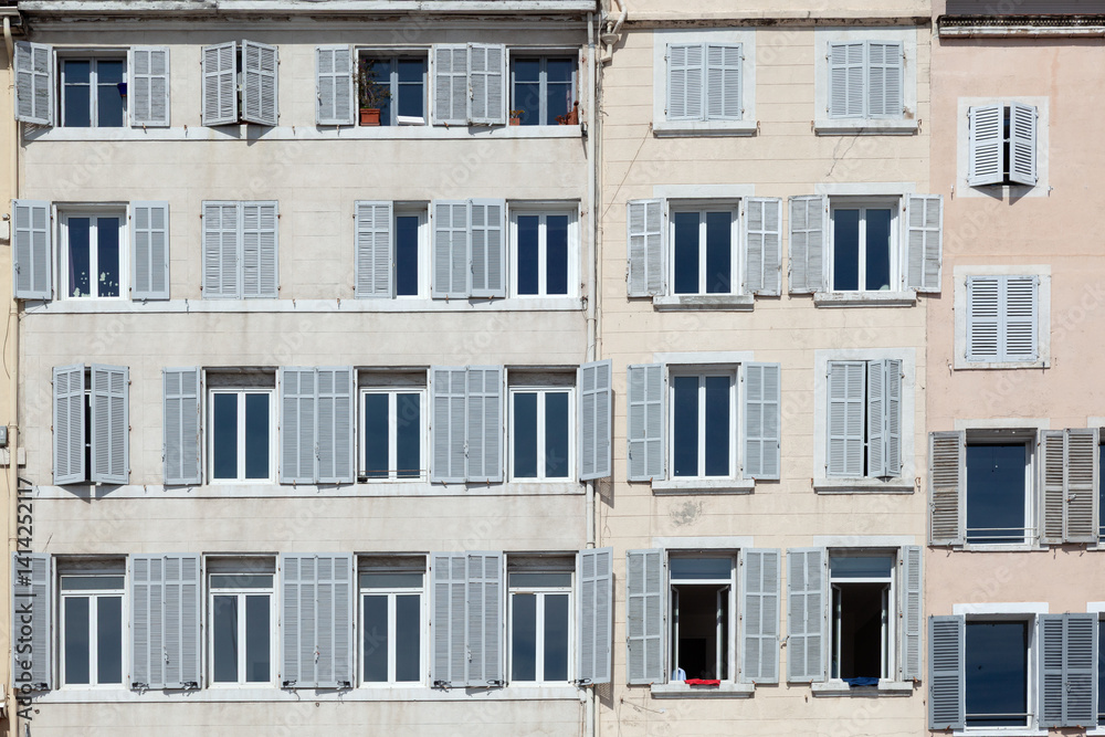 typical facade of an old hotel with open and closed shutters typical facade of an old hotel with open and closed shutters