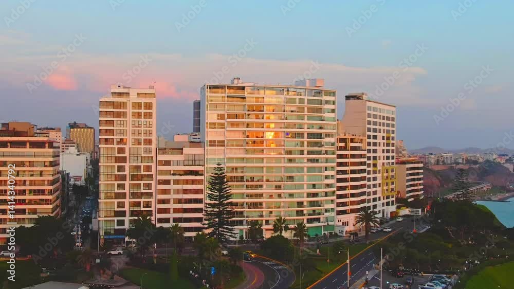 Sunset view of Malecon in Miraflores, Lima with tall buildings and coastal road