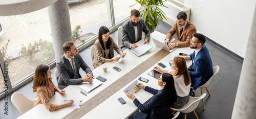 Top view of group of businesspeople sitting at boardroom and discussing data analytic.