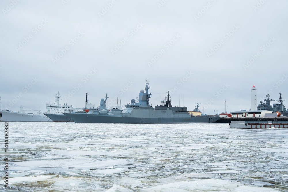 Obraz premium Military ships docked at harbor during winter season in the city of Kronstadt, Russia - March 06, 2025