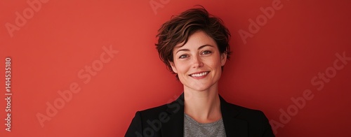 Portrait of Smiling Female CEO Against Vibrant Red Background with Shadow Cast on One Side