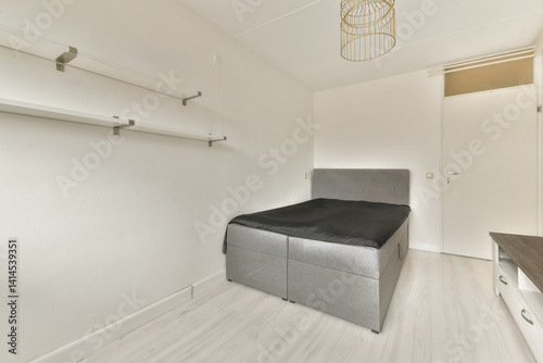A simple and modern interior of a bedroom featuring a sleek black bed and neutral-toned walls  designed for a minimalist aesthetic.