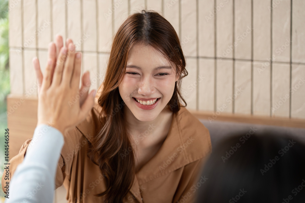 Teamwork and Encouragement. A student sharing a high-five with her friend in a lively study moment. Teamwork and Encouragement. A student sharing a high-five with her friend in a lively study moment.