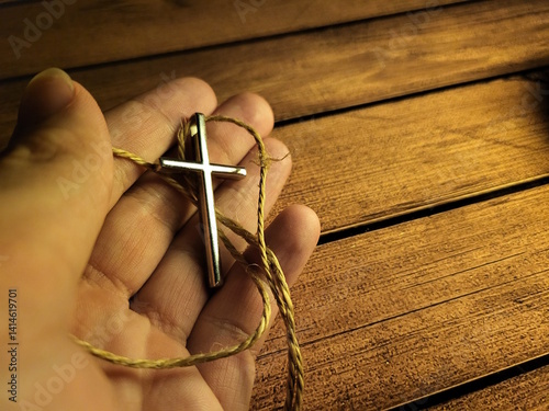Hand Holding Christian Cross Pendant – Symbol of Faith and Devotion
