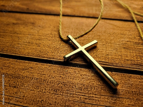 Metal Christian Cross Pendant on Wooden Table – Faith and Spiritual Symbol