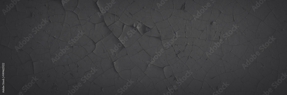 Dark wide panoramic background. Peeling paint on a concrete wall. Faded dark texture of old cracked flaking paint. Weathered rough painted surface with patterns of cracks. Shaded background for design