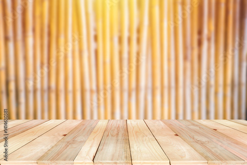 Wooden board empty table on the front with blurred bamboo wooden pattern line background. Empty space for text or product.