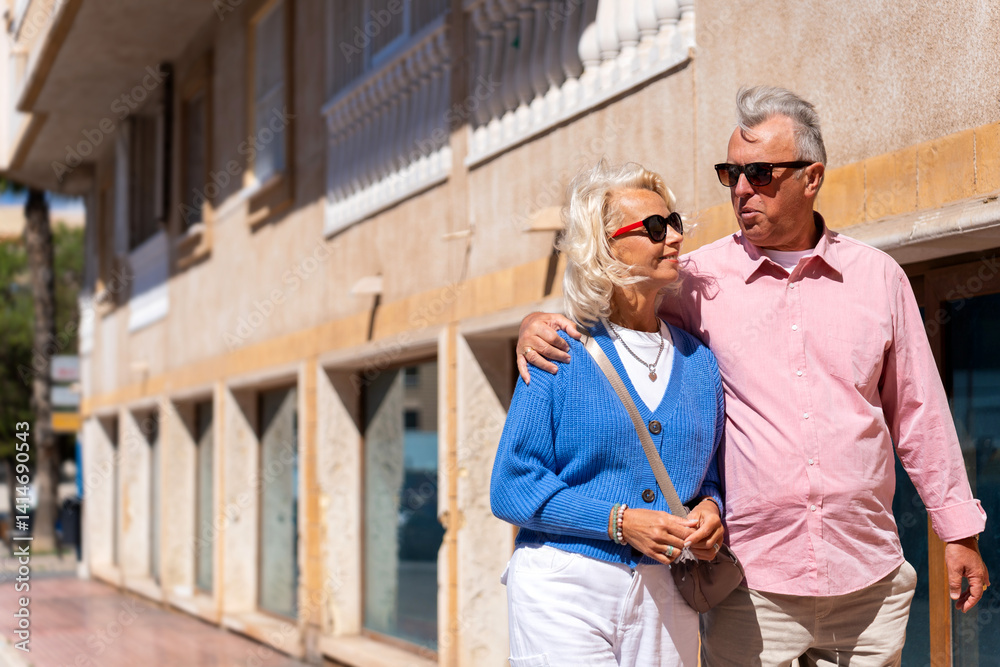 Senior couple enjoying sunny stroll on vacation Senior couple enjoying sunny stroll on vacation