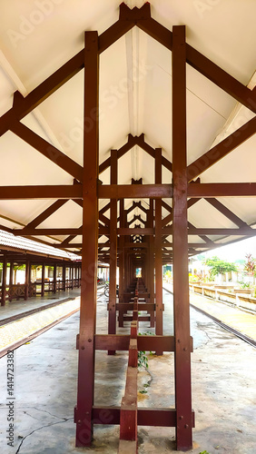 Fototapeta Naklejka Na Ścianę i Meble -  Wooden Train Station Platform: A long perspective view of a train station platform with a wooden structure.