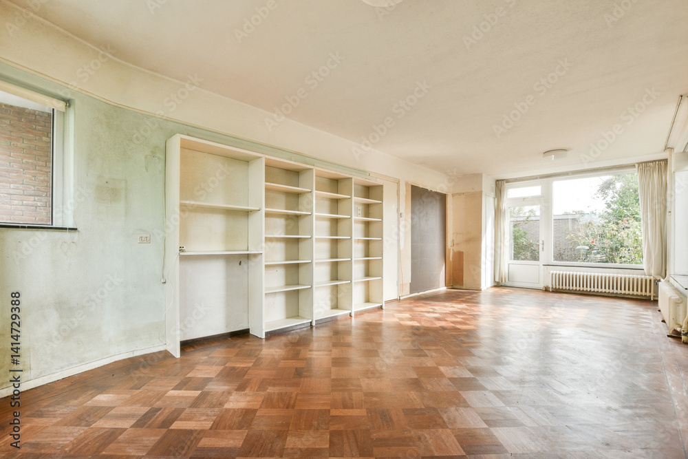 Obraz premium A vacant room featuring large windows that allow natural light to flood in, highlighting the wooden floor and white walls. Perfect for renovation or new decor.