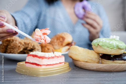 woman dealing with binge eating disorder, eat a lot of fast food like burgers, fried chicken, donuts, and desserts, showing unhealthy eating habits and emotional stress related to food photo