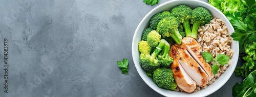 Succulent grilled chicken slices accompany nutritious brown rice and vibrant broccoli in a bowl perfect for balanced diets