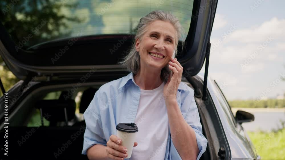 Joyful smiling Caucasian senior elderly laughing woman mature female business woman freelancer pensioner tourist auto driver talk mobile cell phone answering call smartphone drink coffee at city park