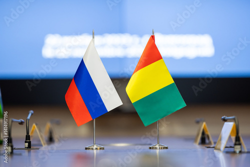 Flags of cooperation between Russia and Guinea. Flags of Russia and Guinea on the negotiating table. Perfect for news.