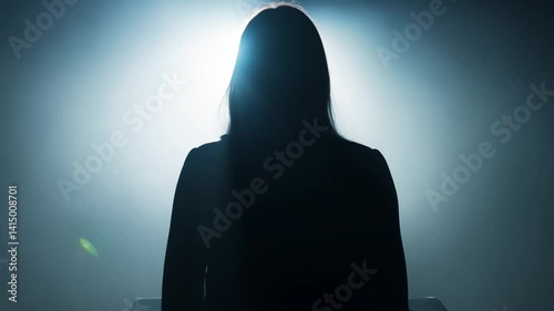 Anonymous woman silhouette sitting backlit