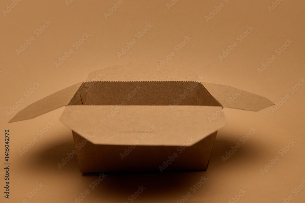 Open empty brown cardboard container on brown surface, eco packaging. Concept of zero waste, food delivery, storage solution. Design mockups, sustainability projects, packaging catalogs