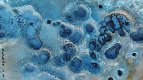 Bird’s-eye view of a surreal geothermal landscape at Hverir, Iceland, with steaming vents, textured mud crusts, and mineral contrasts.