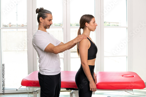 Male osteopath doing a postural evaluation