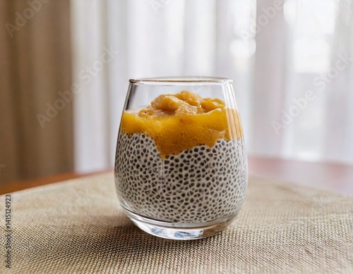Minimalist breakfast scene with chia pudding in a clear glass, side angle, soft morning light.