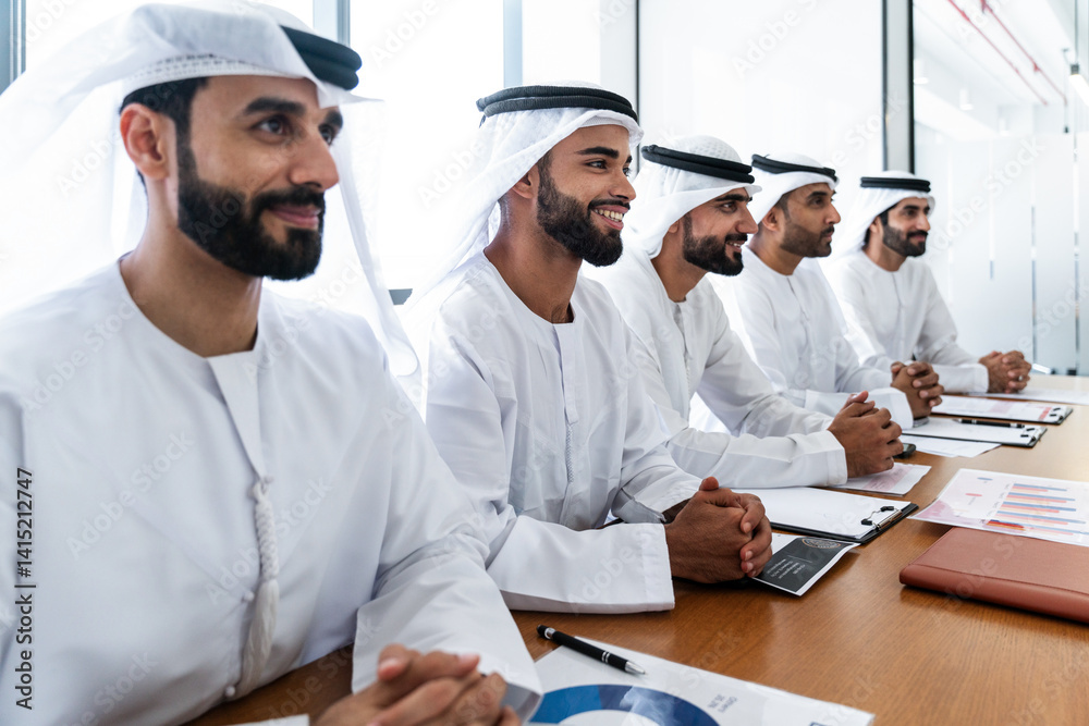 Arab businessmen wearing emirati kandura meeting in office for business deal - Corporate business group of middle-eastern people working in an international company in middle east Arab businessmen wearing emirati kandura meeting in office for business deal - Corporate business group of middle-eastern people working in an international company in middle east
