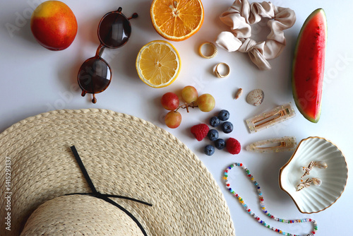 Obraz na płótnie Straw hat, sunglasses, seasonal fruit, seashells and colorful accessories on white backgrounds. Cute summer essentials. Flat lay. w salonie