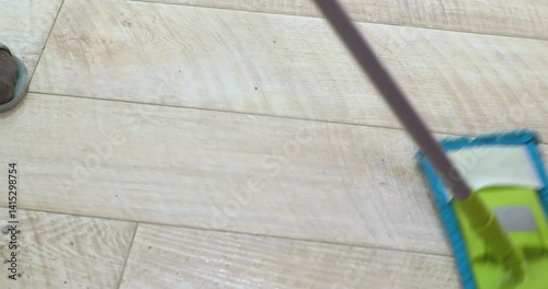 Housekeeper cleaning floor with microfiber mop