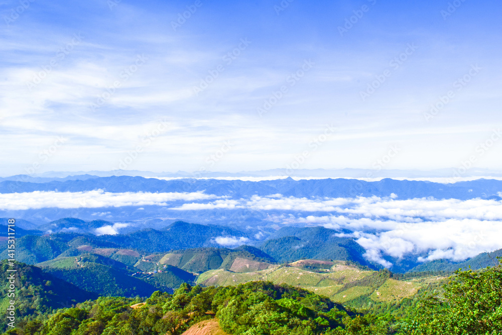 Naklejka premium Scenic Mountain Landscape with Blue Sky and Layers of Misty Hills