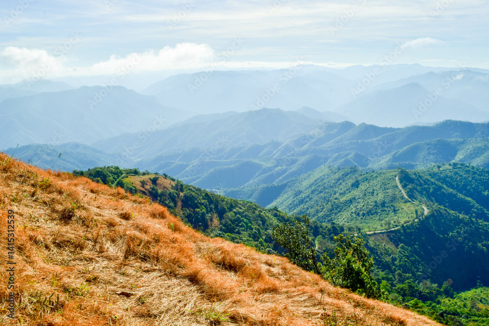 Fototapeta premium Scenic Mountain Landscape with Blue Sky and Layers of Misty Hills