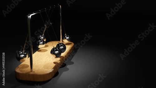 Swinging Newton’s cradle on a wooden base illustrates kinetic motion