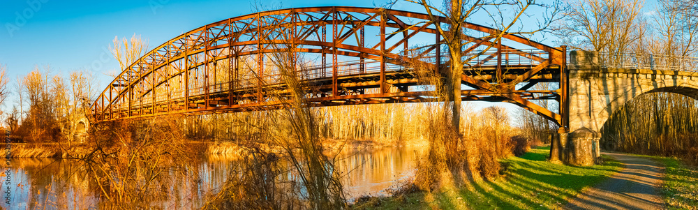 Winter landscape with an old railway bridge and reflections on a sunny evening near Landau an der Isar, Dingolfing-Landau, Bavaria, Germany