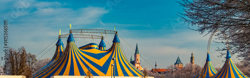 Obraz na płótnie A church and yellow blue circus tents on a sunny winter day at Straubing, Straubing-Bogen, Bavaria, Germany w salonie