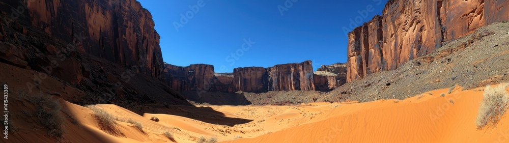 Fototapeta premium Spectacular view of a desert canyon with towering rock formations and sandy terrain.