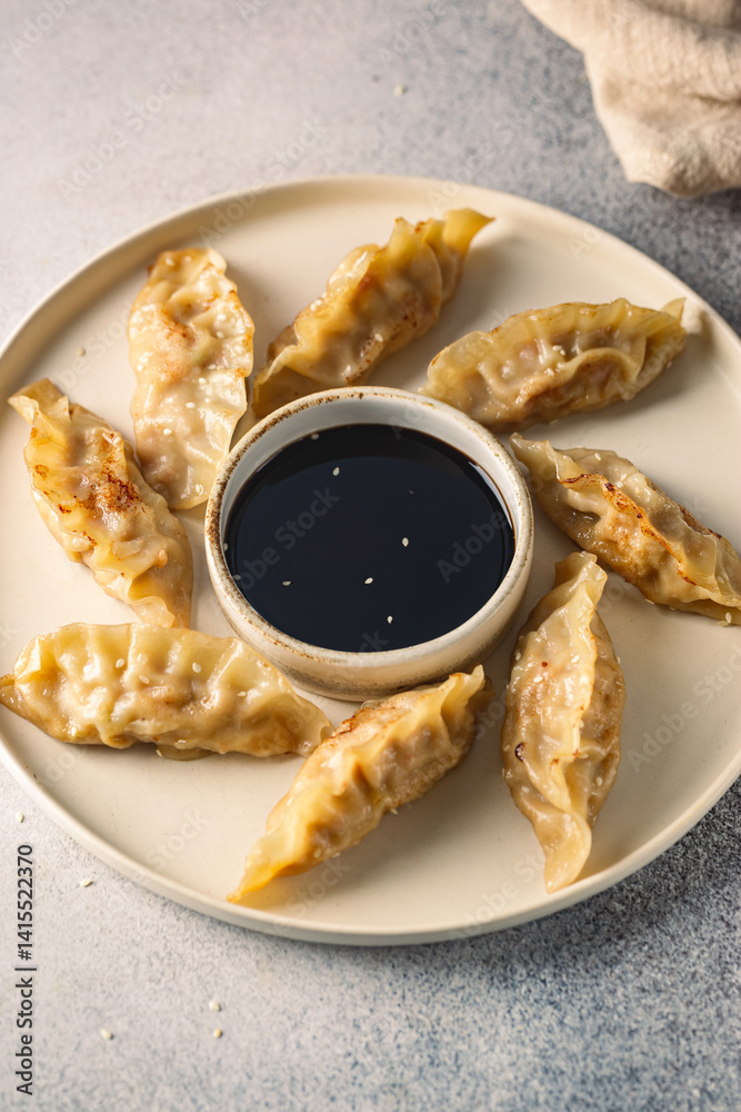 Asian dumplings with soy sauce and sesame seeds. Traditional chinese dim sum dumplings on white plate.