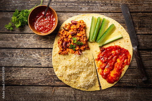Obraz na płótnie Tortilla wraps sandwiches with fresh vegetables, minced meat and on wooden background. Burrito, sandwich wrap, fajita wrap w salonie