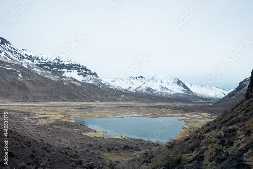 Woman on vacation in a cave with a lagoon in the background.
