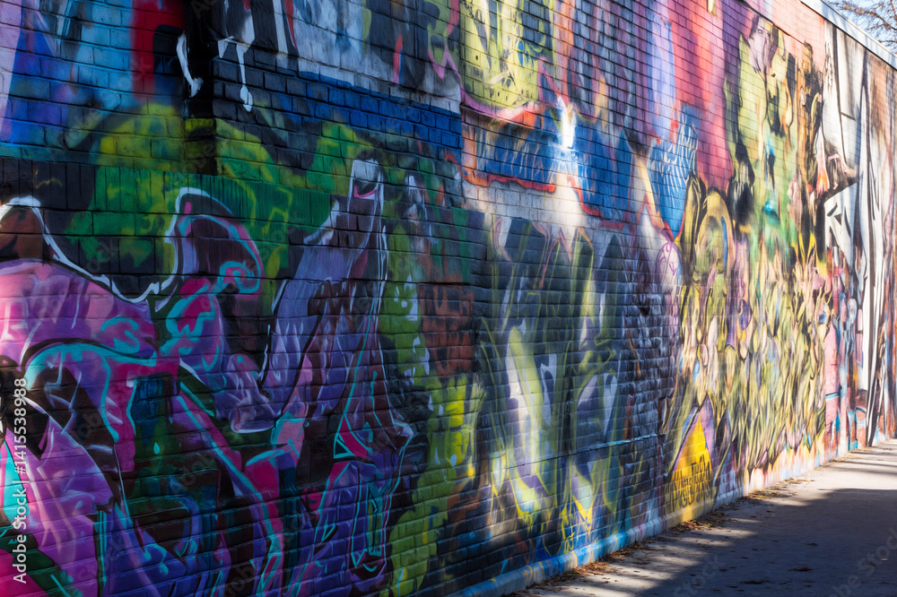 The image shows a vibrant, colorful mural painted on a brick wall