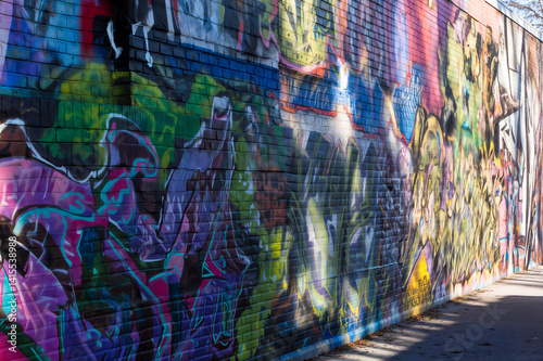 Obraz na płótnie The image shows a vibrant, colorful mural painted on a brick wall w salonie