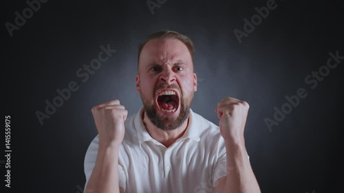 A man with a beard and stern expression poses confidently in a white shirt, exuding authority and self-assurance.