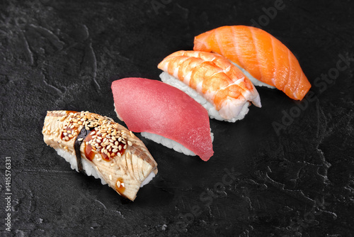 Obraz na płótnie Delicious nigiri sushi with eel, tuna, shrimp and salmon on black background w salonie