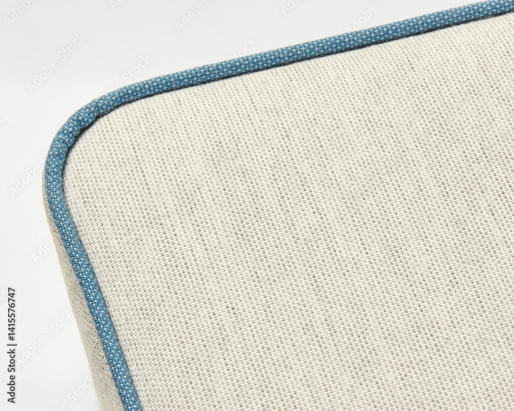 Beige linen upholstery with blue piping creates a textured surface