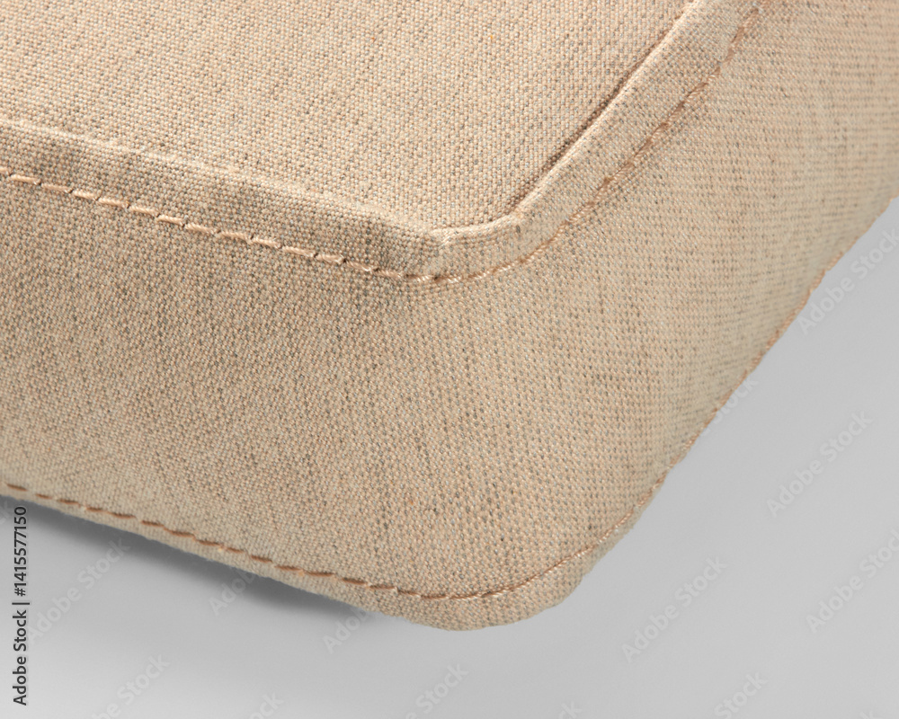Corner of beige canvas cushion showing stitching detail