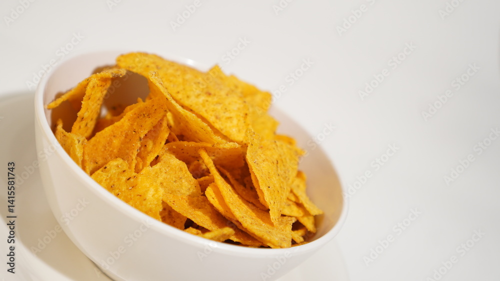 Irresistible bowl of crispy tortilla chips on a pristine white backdrop Irresistible bowl of crispy tortilla chips on a pristine white backdrop