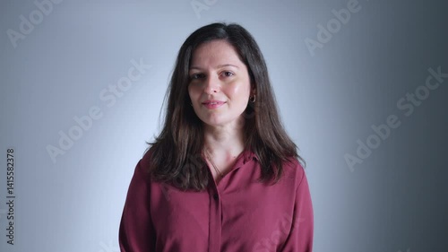 A woman in a red shirt poses confidently, exuding warmth and approachability. Her smile and direct gaze create a sense of connection and trust.