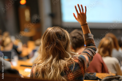 A college student raising her hand in a lecture photo