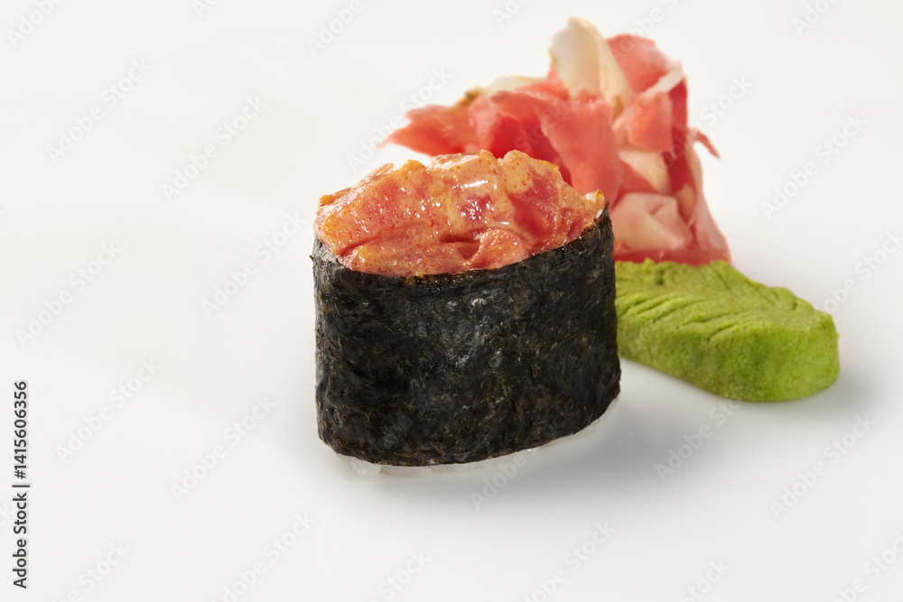 Gunkan maki sushi with spicy tuna, ginger and wasabi on white background