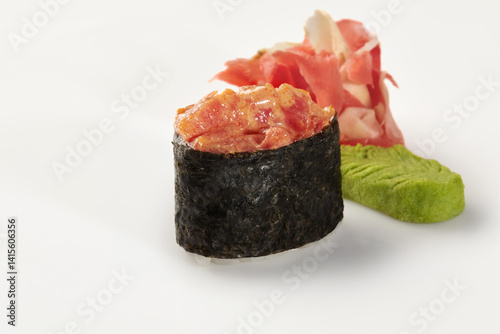 Gunkan maki sushi with spicy tuna, ginger and wasabi on white background