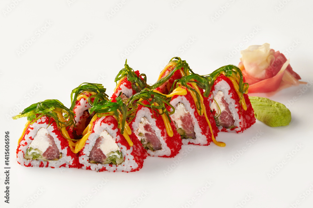 Triangular sushi rolls covered in red tobiko with chuka seaweed and spicy mayo on white background